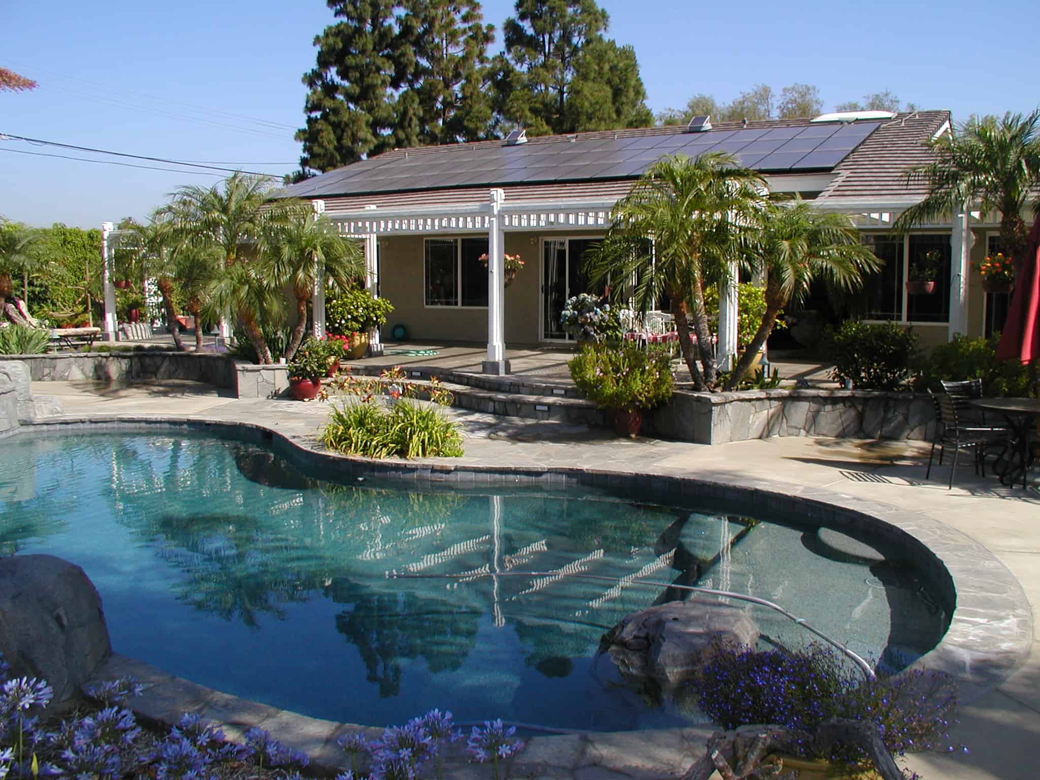 Navigating Challenging Times Together. Home with a swimming pool being heated by solar by Sunergy Systems.