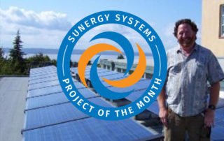 Edmonds Community Solar Cooperative Pioneers New Cooperative Solar Model installed by Sunergy Systems with a man smiling in front of it.