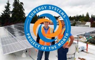 Conscientious Grocers Go Solar. Installers are smiling on the roof of a home.