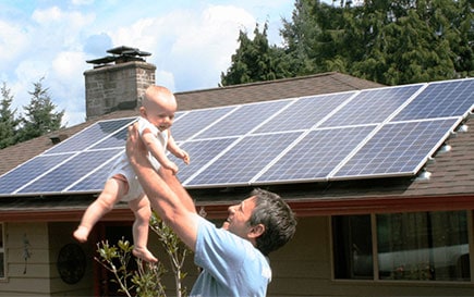 man lifting his child into the air over solar system in washington state
