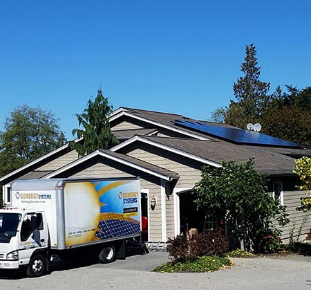 A home with residential solar and Sunergy work truck parked out front