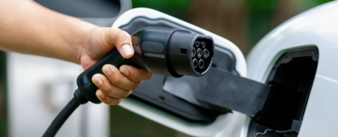 Close-up of an electric vehicle being charged, showcasing Synergy Systems' solar-powered EV charging solutions for sustainable energy.
